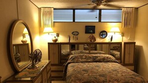 Ein Schlafzimmer mit Bett, Kommode, Spiegel und zwei Nachttischlampen.