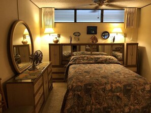 A bedroom with a bed, dresser, mirror, and two bedside lamps. - One Bedroom Ocean View (Kihei)