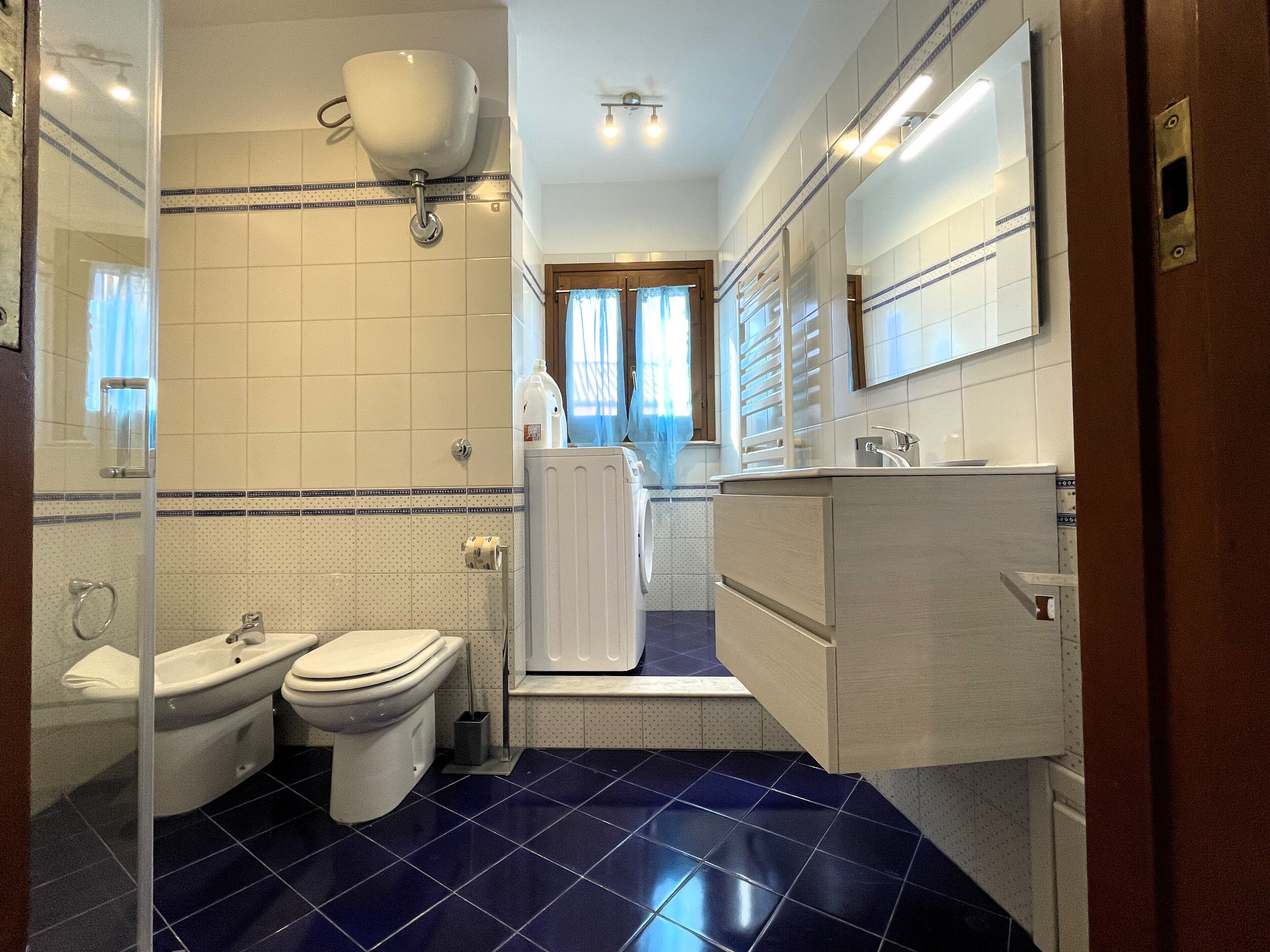 A bathroom with a toilet, bidet, and sink.
