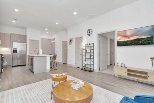 A modern apartment with a kitchen, dining area, and living room.