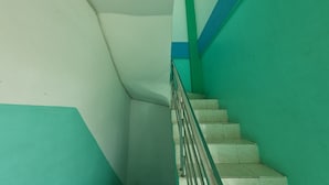 Una escalera con paredes verdes y escalones blancos.