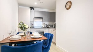 Eine moderne Küche mit weißen Schränken, einer Mikrowelle und einer Uhr an der Wand.