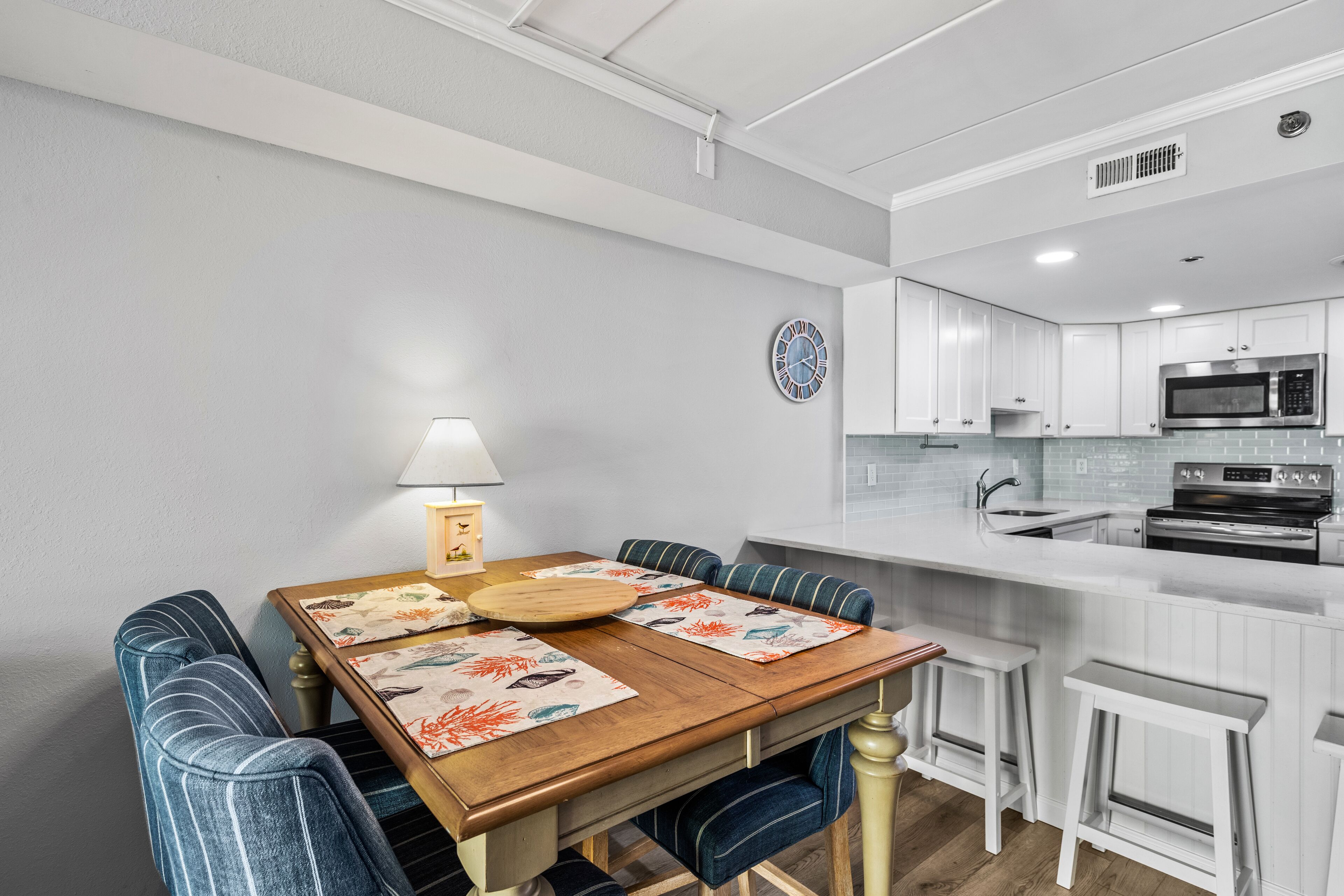 A modern kitchen with white cabinets, a microwave, and a stove.
