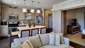 A modern kitchen with a central island, stainless steel appliances, and pendant lighting. - The Pointe by Southern Vacation Rentals (Panama City Beach)