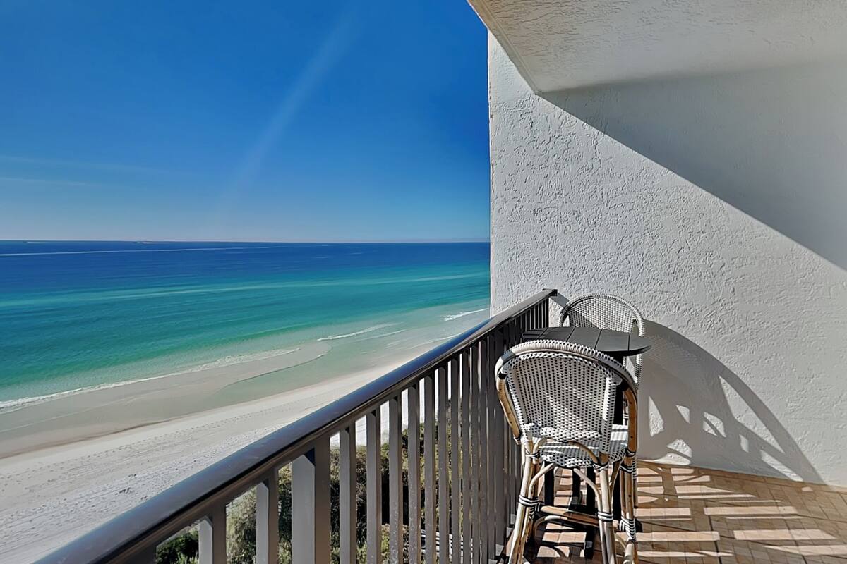 A balcony with a view of a beach and ocean.