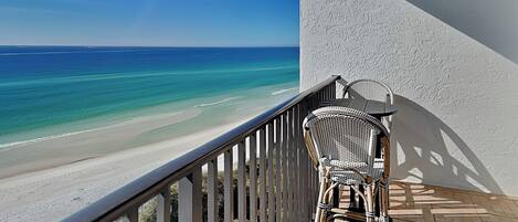 A balcony with a view of a beach and ocean.