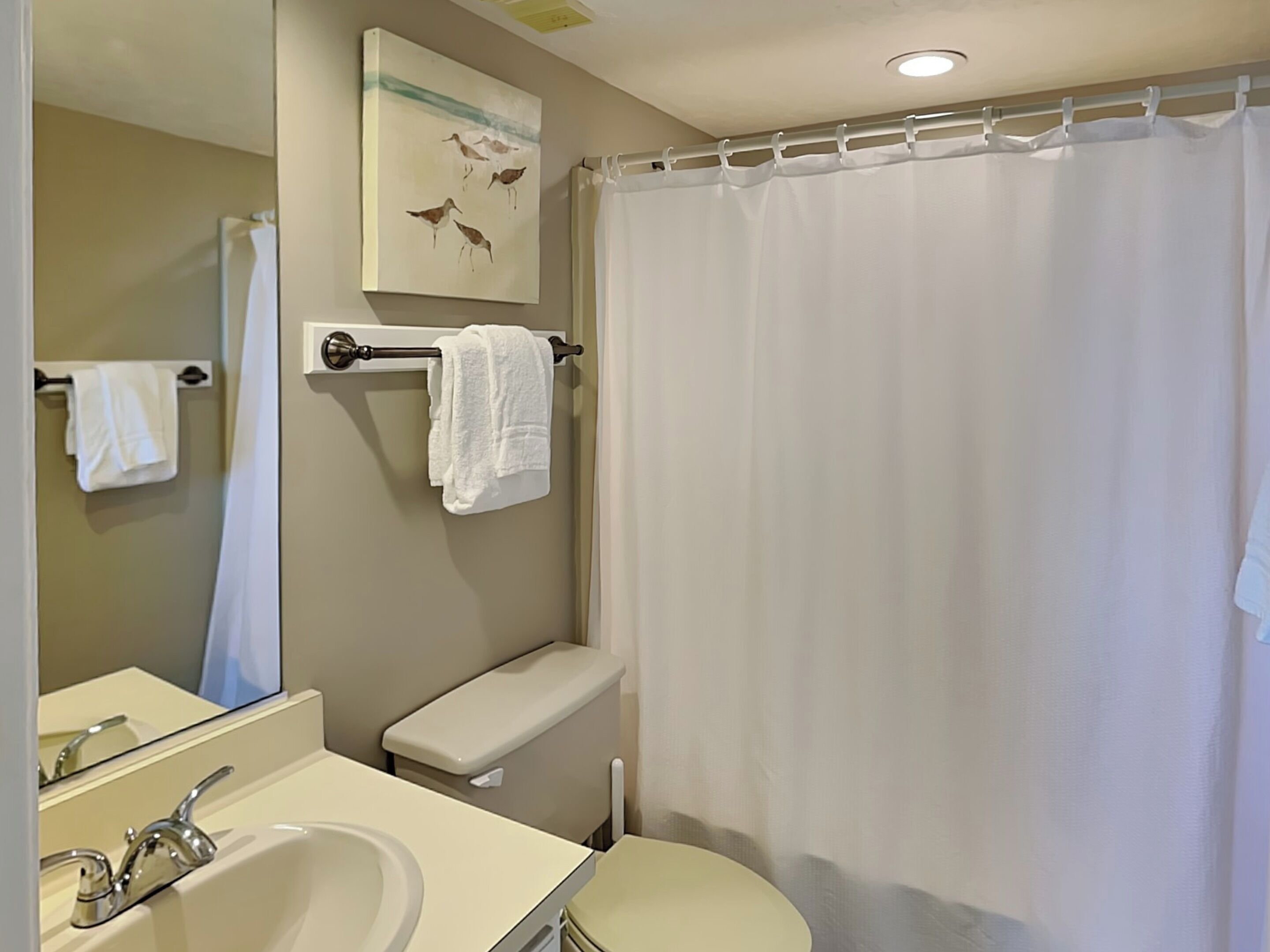 A bathroom with a sink, toilet, and shower curtain.
