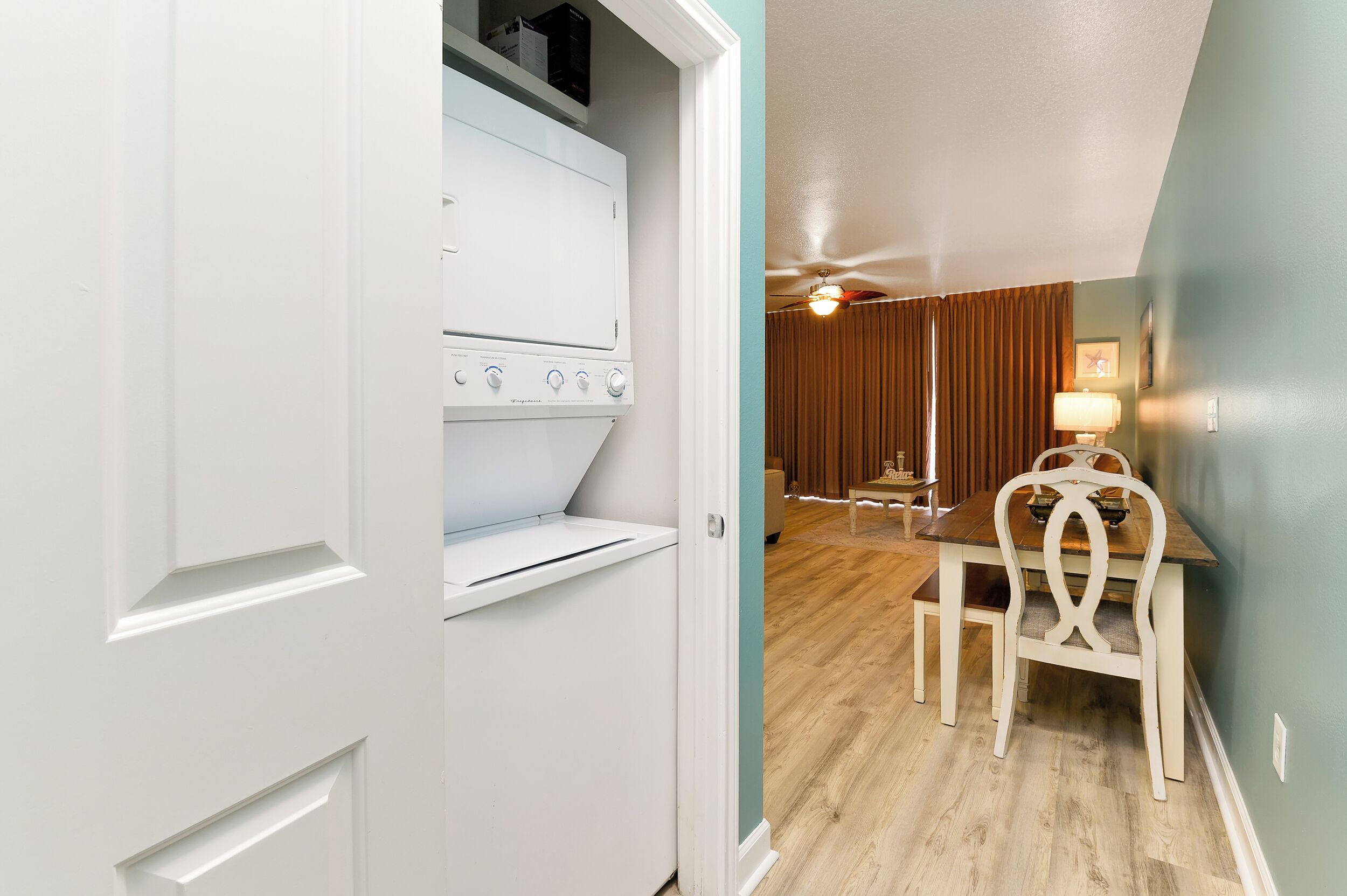 A room with a white oven, a dining table with chairs, and a ceiling fan.