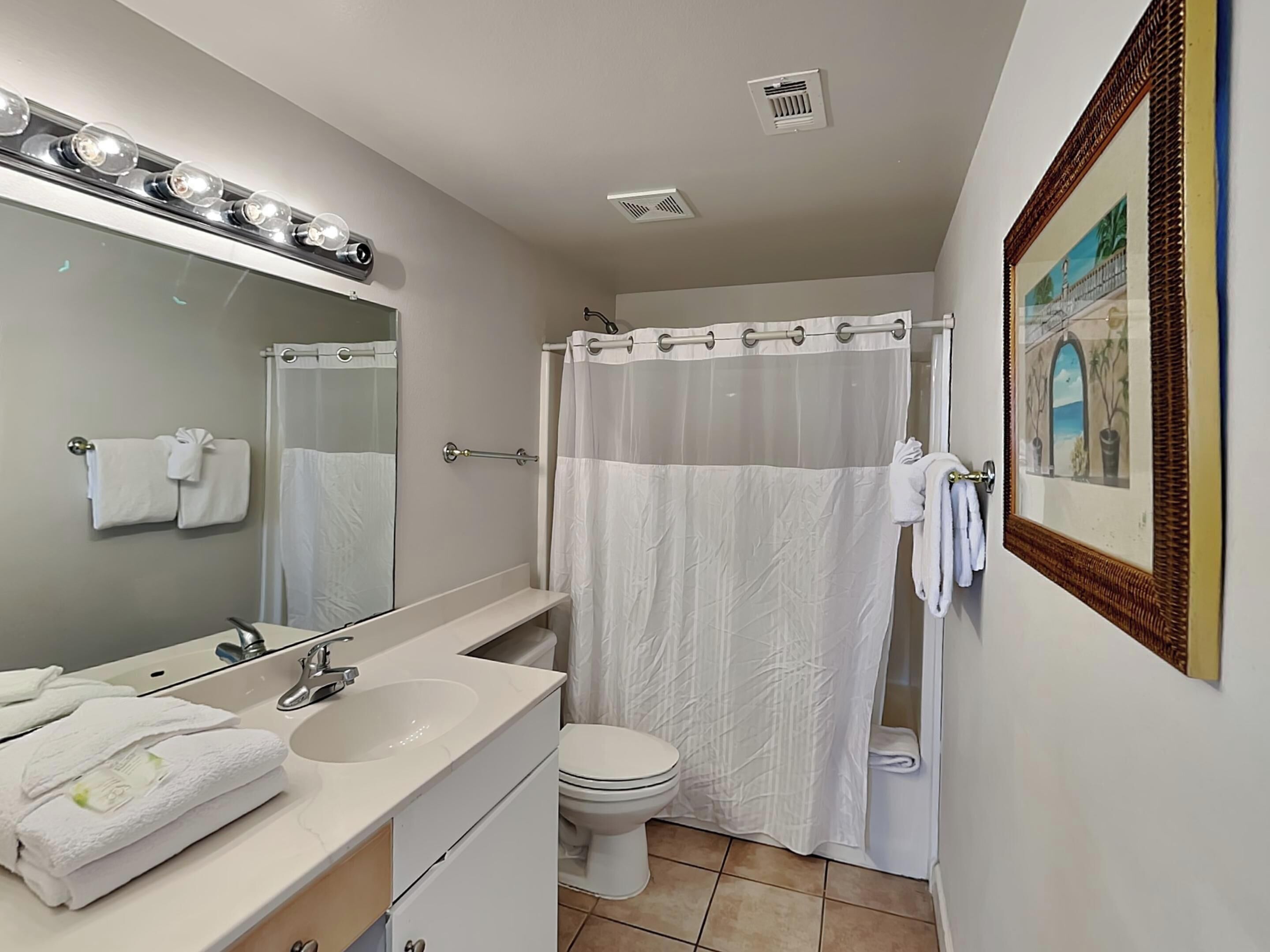A bathroom with a sink, mirror, and toilet.