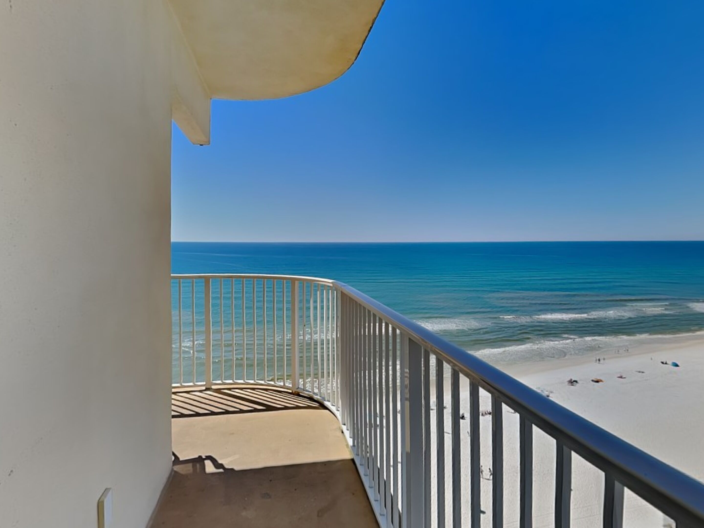 Un balcon avec vue sur une plage et l’océan.