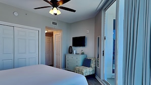 A bedroom with a bed, a dresser, a television, and a ceiling fan. - The Palms of Destin by Southern Vacation Rentals (Destin)