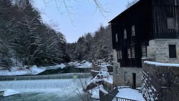 A snow-covered outdoor area with a wooden building, a stone wall, and a river. - Private Cottage minutes from Moraine State Park and McConnell's Mill State Park. (Portersville)