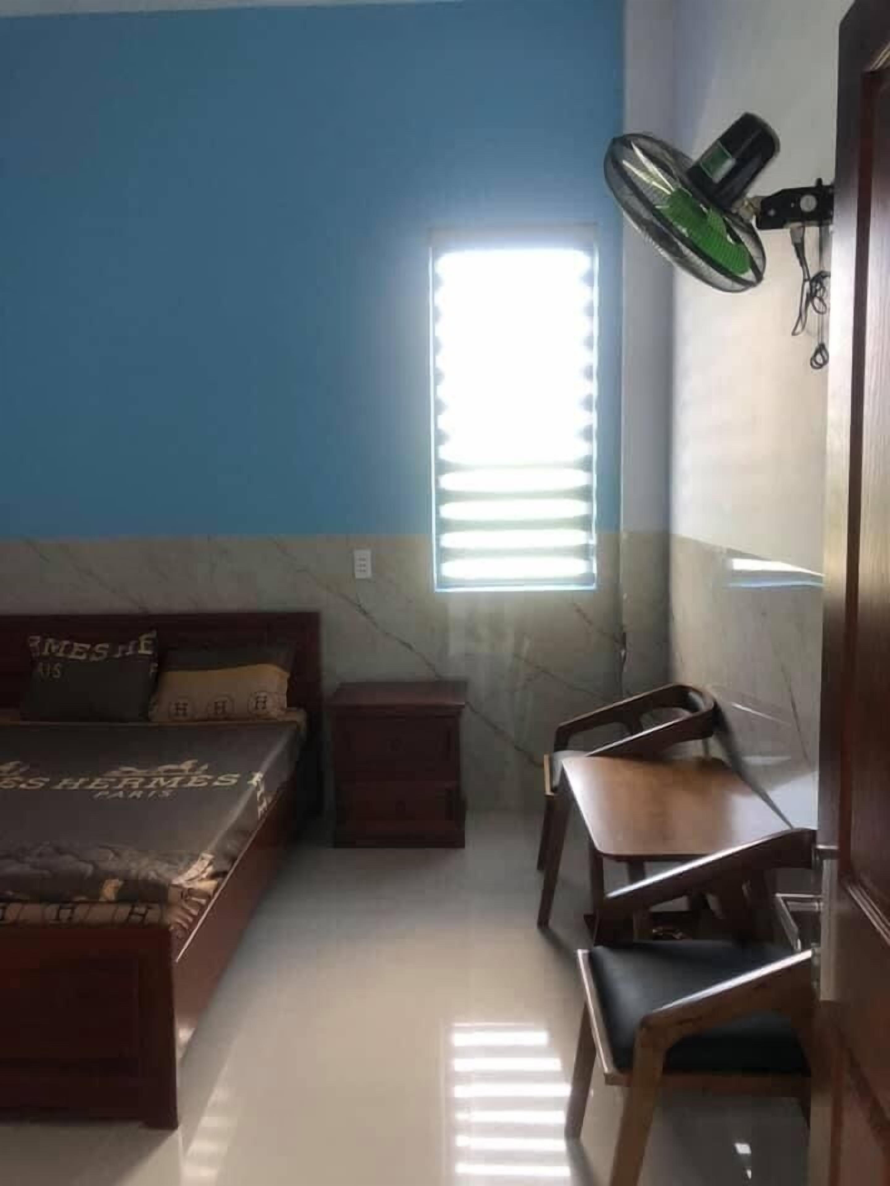 A bedroom with a bed, a desk, and a chair.