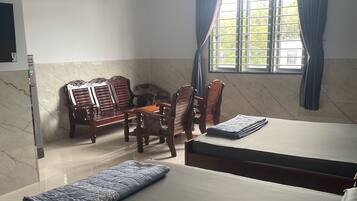 A hotel room with a bed, a desk, and two chairs.