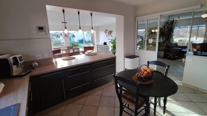 Uma cozinha moderna com ilha central, armários pretos e iluminação pendente.