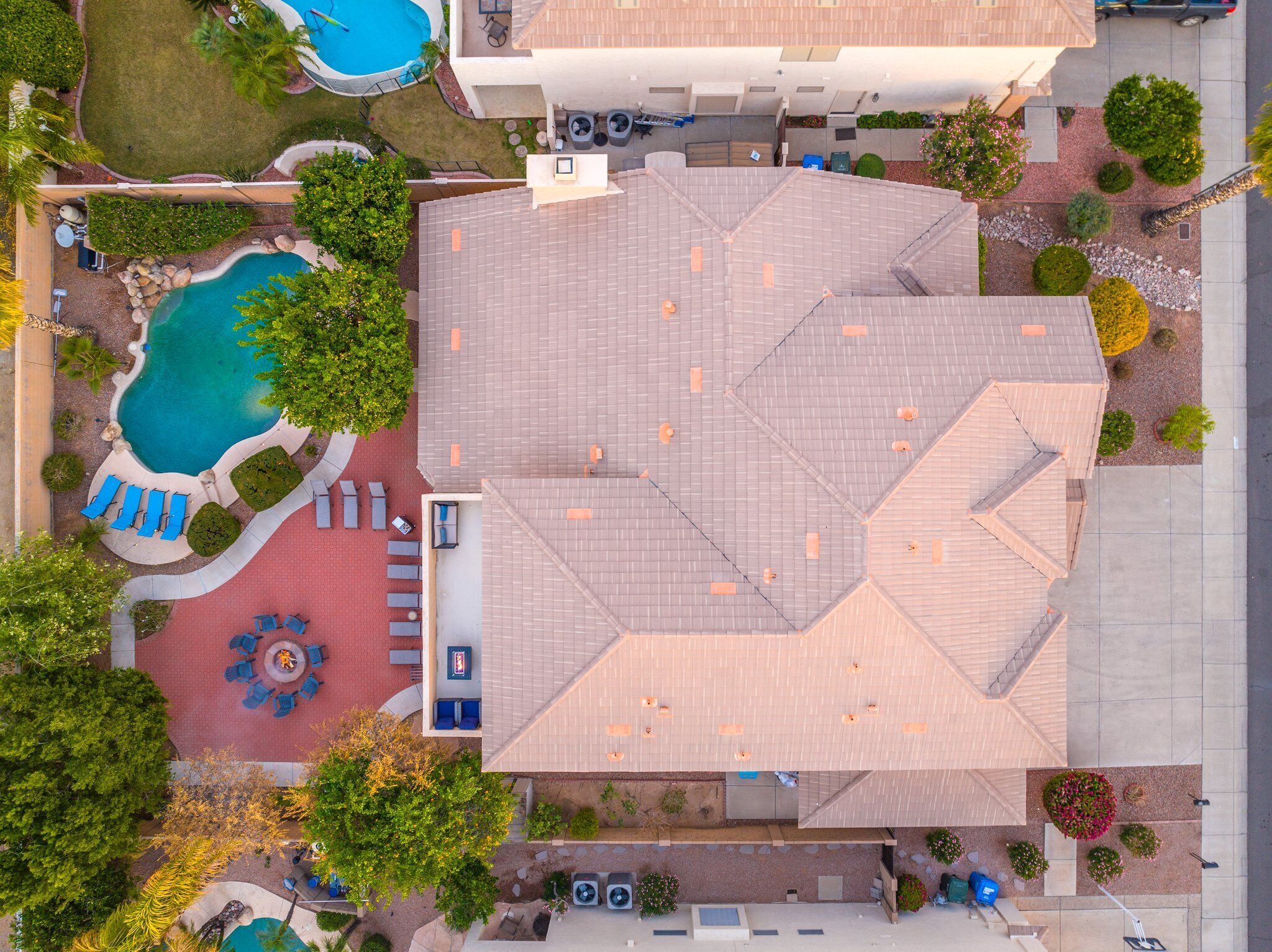 Vista aérea de um hotel com piscina, áreas de estar ao ar livre e jardins bem cuidados.