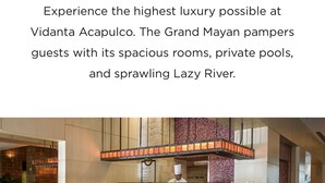 A spacious dining area with multiple tables and chairs, a central bar, and a high ceiling with decorative lighting.