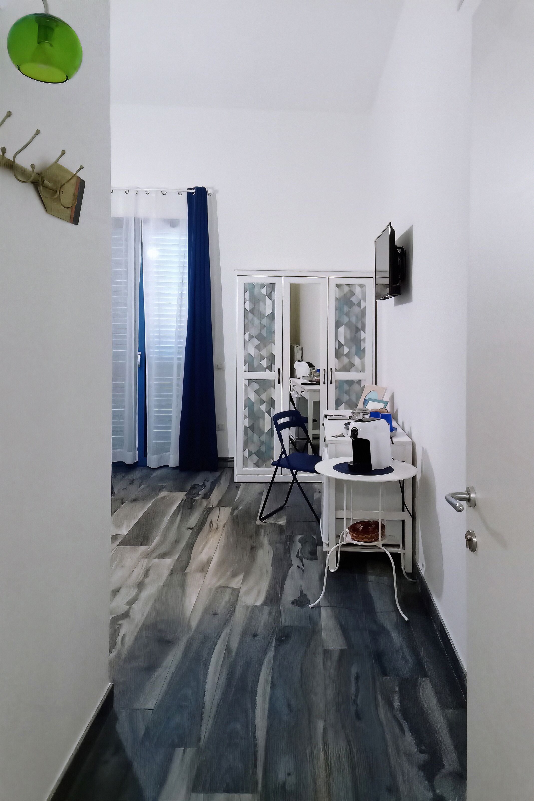 Una habitación pequeña con escritorio, silla y armario.