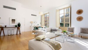 Un salon spacieux comprenant un canapé, une table basse et un coin repas avec des chaises.