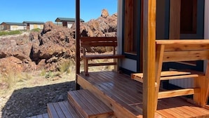 Eine Holzhütte mit Veranda, eingebettet in eine felsige Landschaft.
