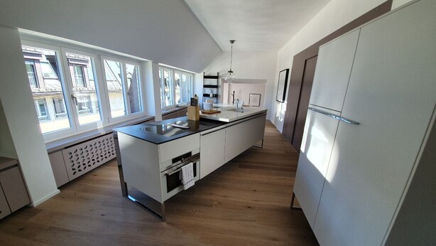 A modern kitchen with a central island, built-in appliances, and large windows providing natural light. - Le Bijou Bahnhofstrasse / Paradeplatz LB18B (Zürich)