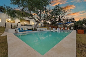 Piscina com espreguiçadeiras e área de estar ao ar livre.