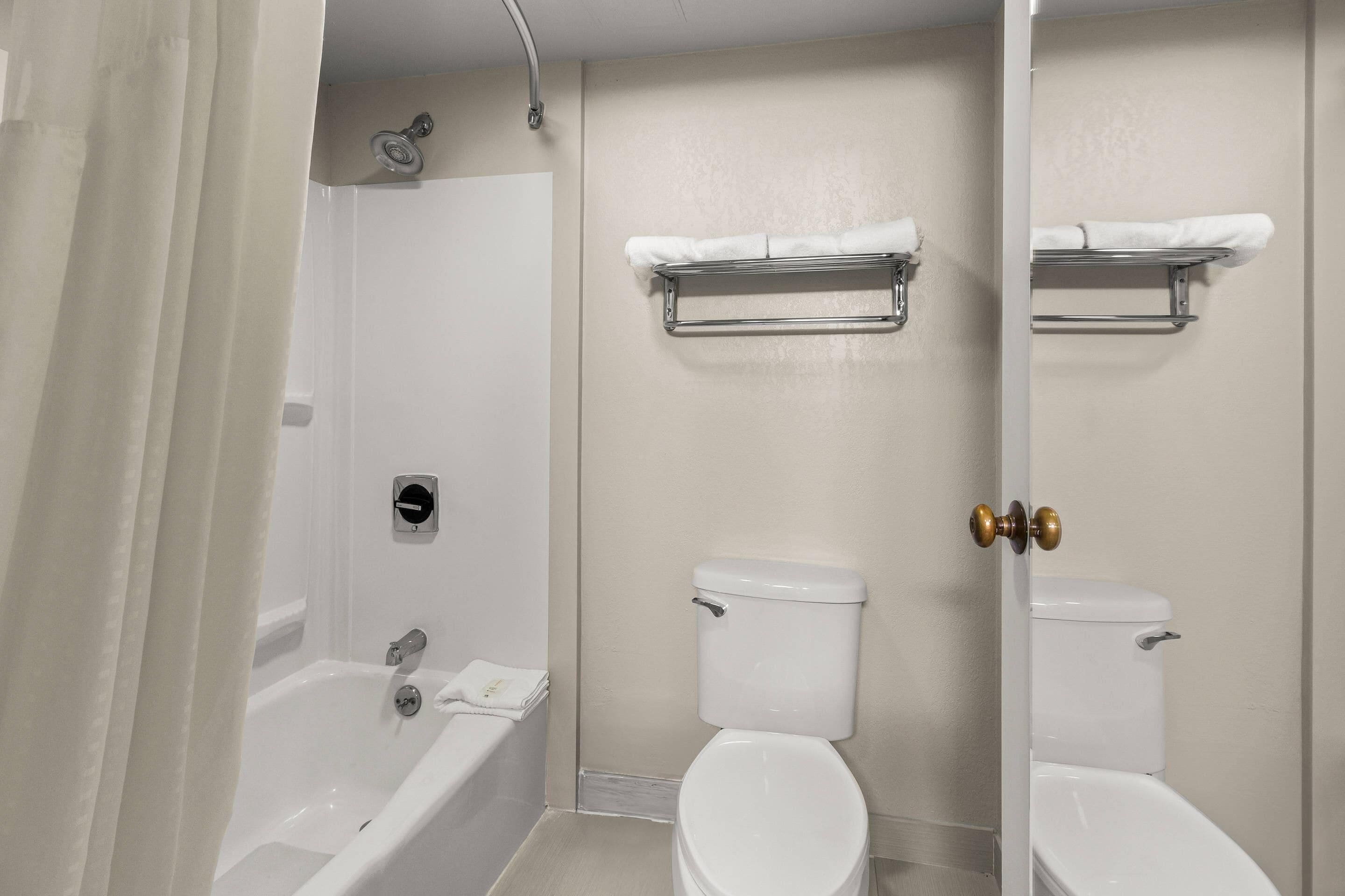 A bathroom with a bathtub, toilet, and shower.