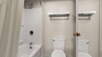 A bathroom with a bathtub, toilet, and shower.