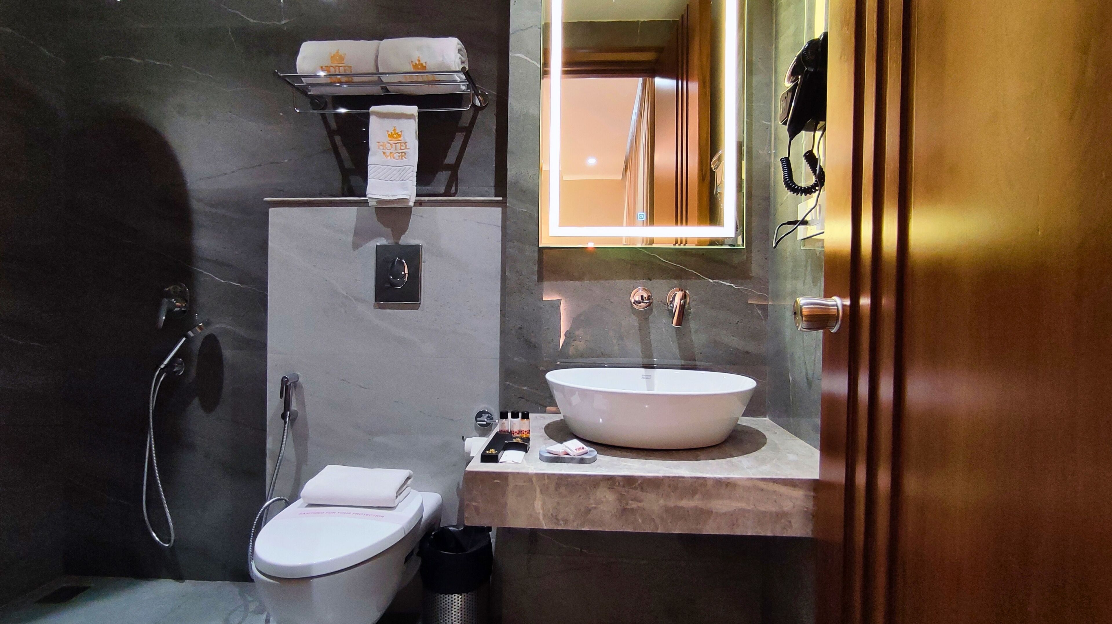 A compact bathroom with a toilet, a sink, and a shower.