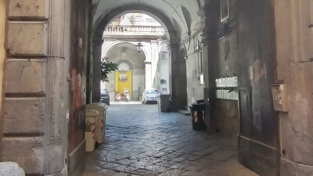 An arched stone gateway with intricate carvings, leading to a cobblestone street. - The Arena - Apartment in the Center. Ideal for sightseeing. Metro 100m away (Napoli)