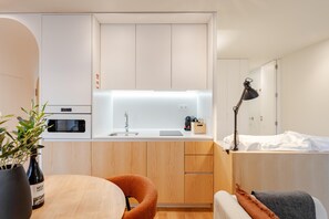 Une cuisine compacte équipée d’un four à micro-ondes, d’un évier et d’un petit plan de travail.