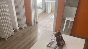 Ein Zimmer mit weißem Tisch, Heizkörper und Spiegel an der Wand.
