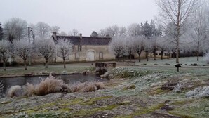 A rustic building with a stone facade, a small pond, and frost-covered trees in a serene setting. - Charming and comfortable apartment in a very pleasant farmyard (Achères-la-Forêt)