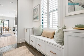 Relax in a stylish room with a bench, storage drawers, and a large window.