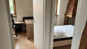 A compact room with a bed, a desk, and a chair. - 4 Bedroom Apartment in TrÃ©venans (Trévenans)