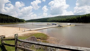 A lake with a dock, surrounded by forested hills. - Ski-In Ski-Out•Hot Tub•King Bed•Sauna•Deck (Snowshoe)