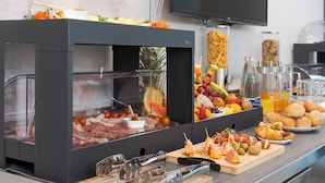 A buffet with various food items including meats, fruits, and beverages. - Emerald Boutique Hotel (Cefalù)
