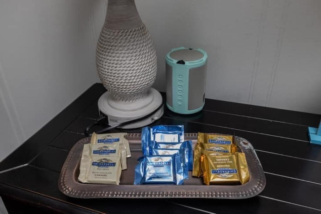 A tray with assorted snacks, a lamp, and a candle on a table.