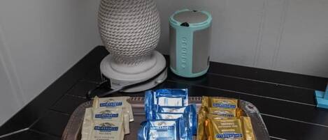 A tray with assorted snacks, a lamp, and a candle on a table.