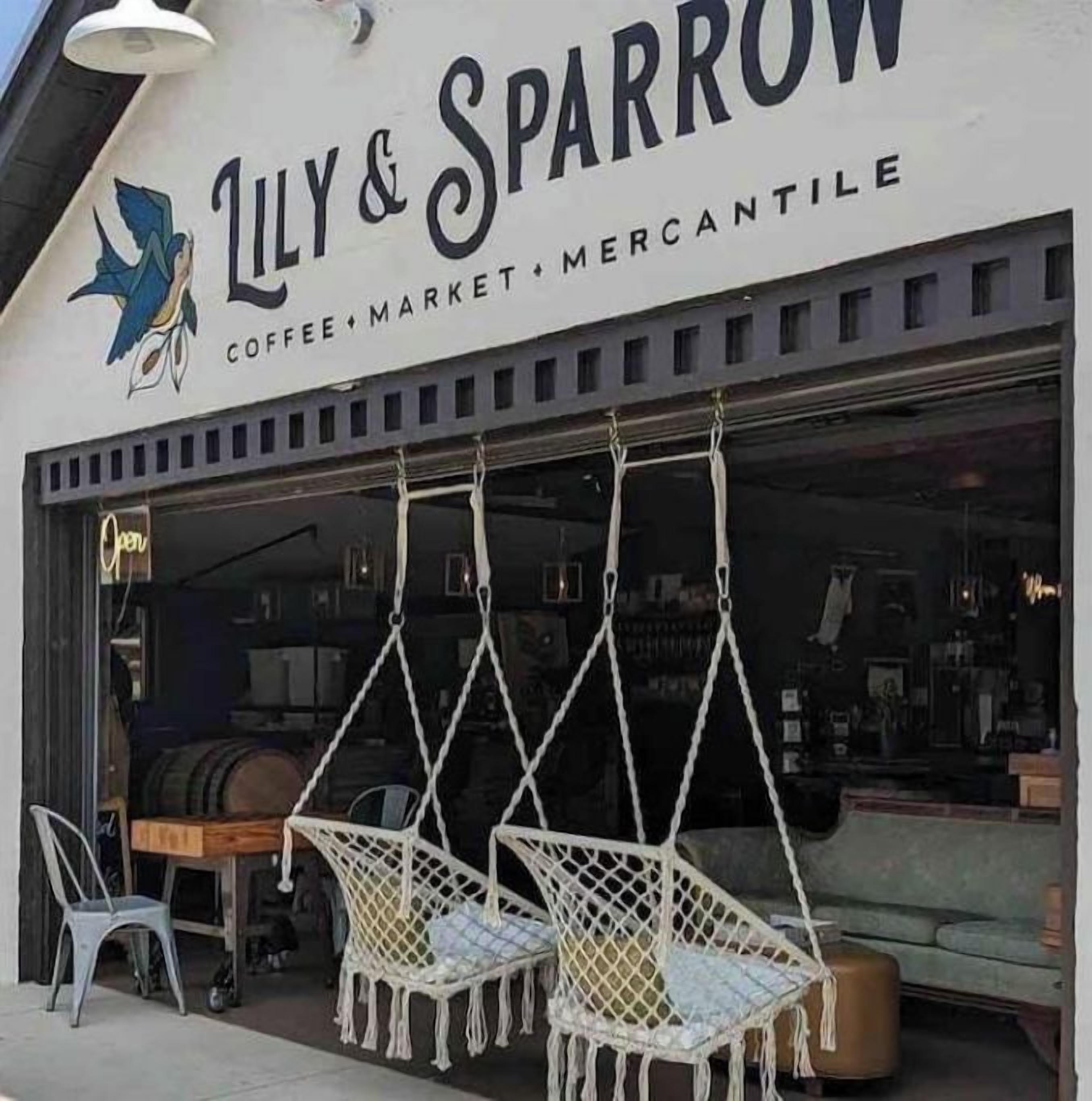 L’extérieur d’un café-épicerie appelé « Lily & Sparrow », avec des places assises en plein air.