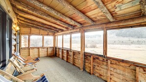 A wooden cabin with a large window, wooden walls, and a carpeted floor. - Yellowstone Cabin Getaway Near National Park (Cameron)