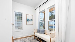 A modern interior with a bench, a large window, and a framed artwork.