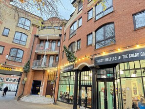 A multi-story building with a ground-floor board game cafe named "Thirsty Meeples."