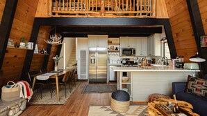A loft-style interior with a dining area, kitchen, and seating space.