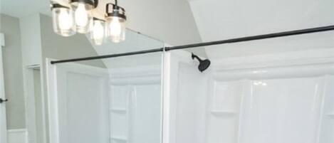 A bathroom with a double sink vanity, a large mirror, and a bathtub.