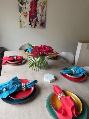 A dining table set with plates, napkins, and a centerpiece.