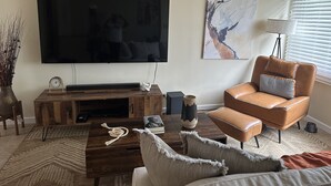 A living room with a flat-screen TV, a coffee table, a sofa, and a chair. - Island Oasis, Near Magens Bay Beach with Back-Up Power System (Charlotte Amalie)