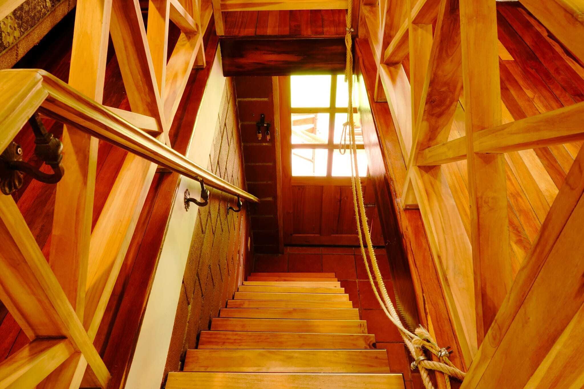 A wooden staircase with a handrail, leading to a door with a window.