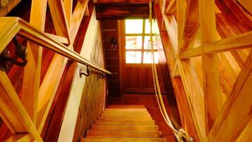 A wooden staircase with a handrail, leading to a door with a window.
