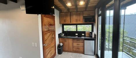Una cocina moderna con armarios de madera, un refrigerador de acero inoxidable y un amplio ventanal con vistas al exterior.